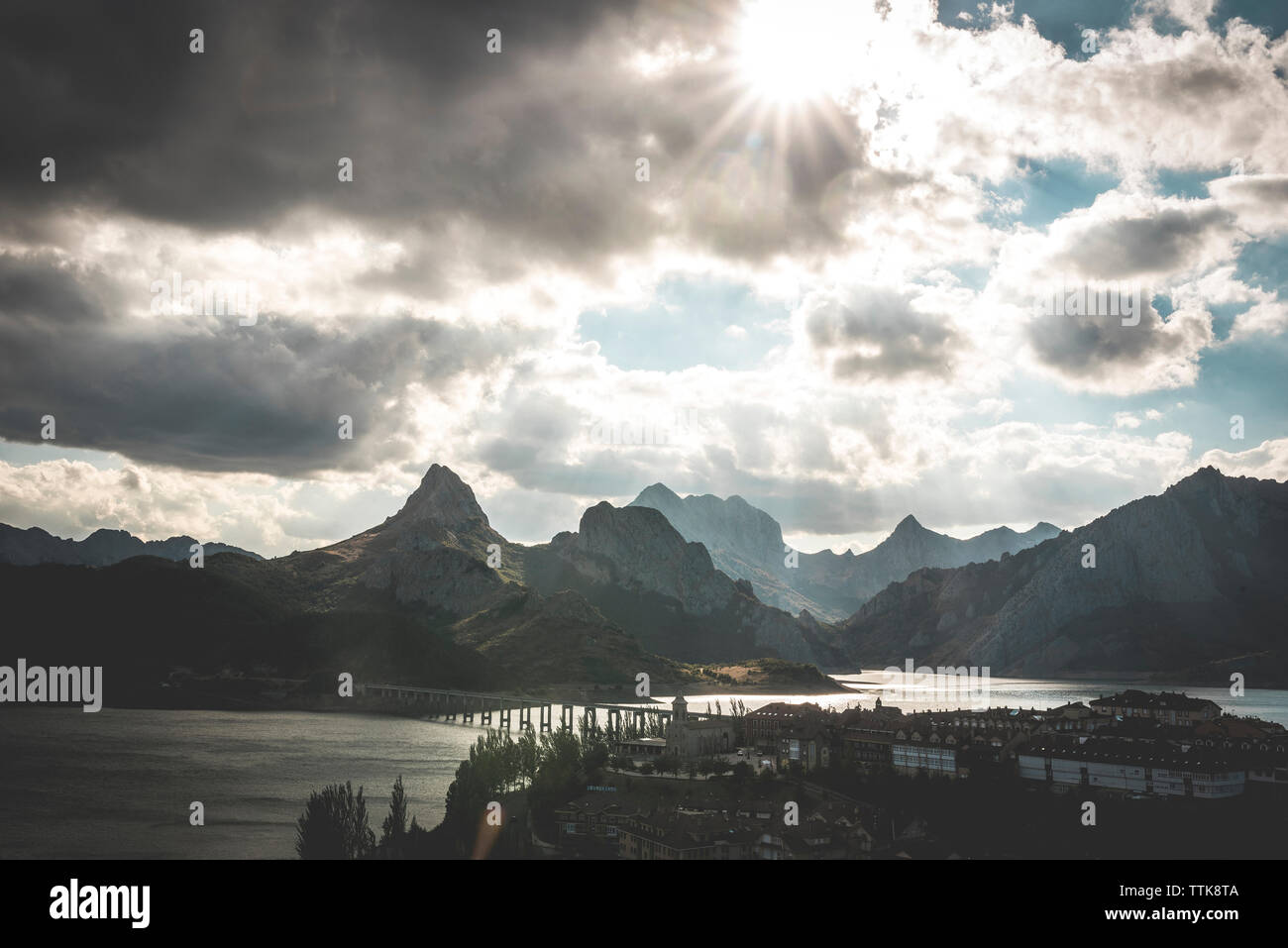 Angolo di alta vista del ponte sul fiume da montagne contro il cielo nuvoloso Foto Stock