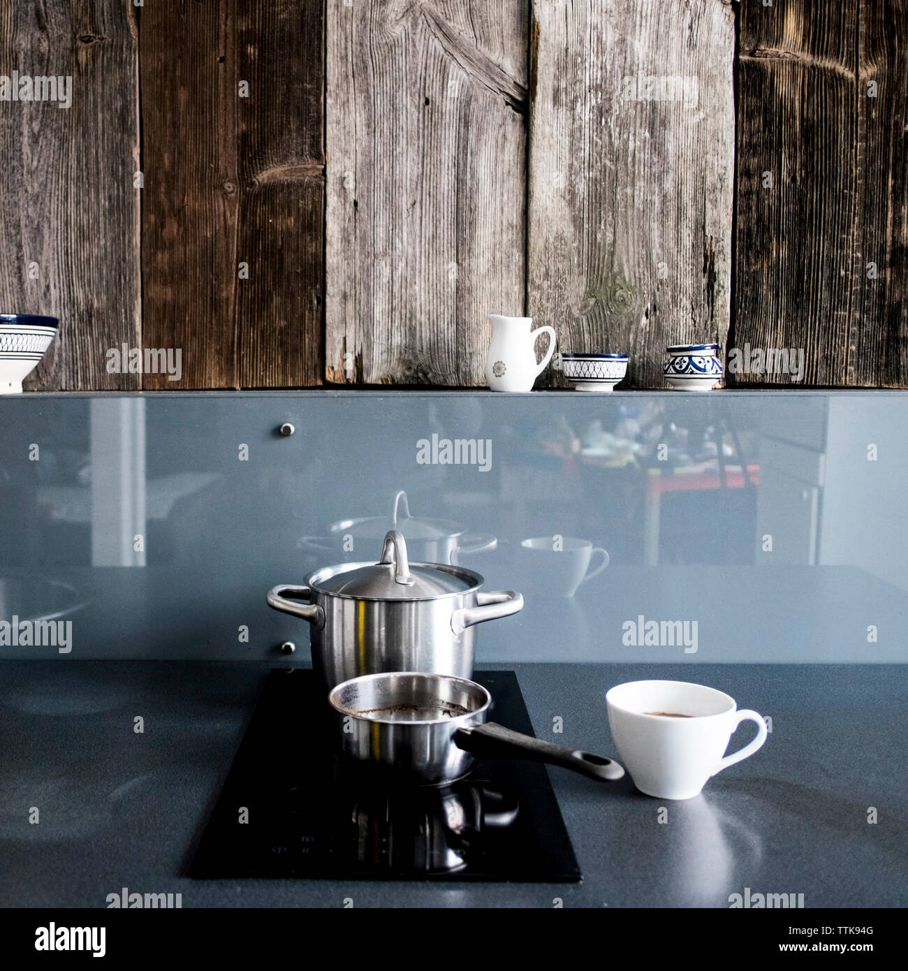 Utensili da cucina a casa contro la parete in legno Foto Stock