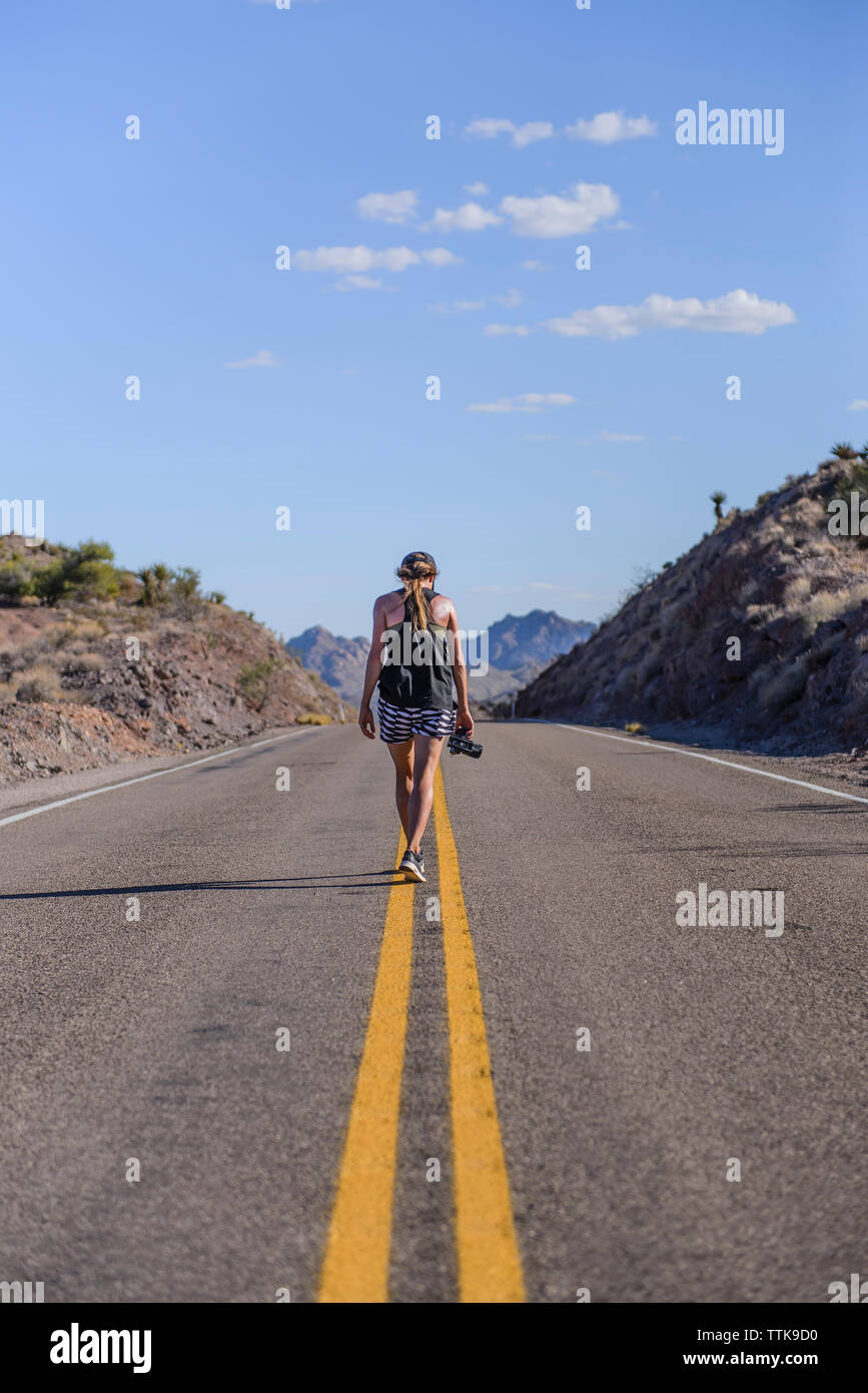 Donna giovane fotografo di viaggio a piedi in mezzo alla strada Foto Stock