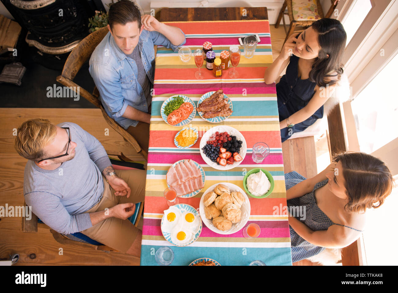 Angolo di alta vista di amici avente pasto a tavola in casa Foto Stock