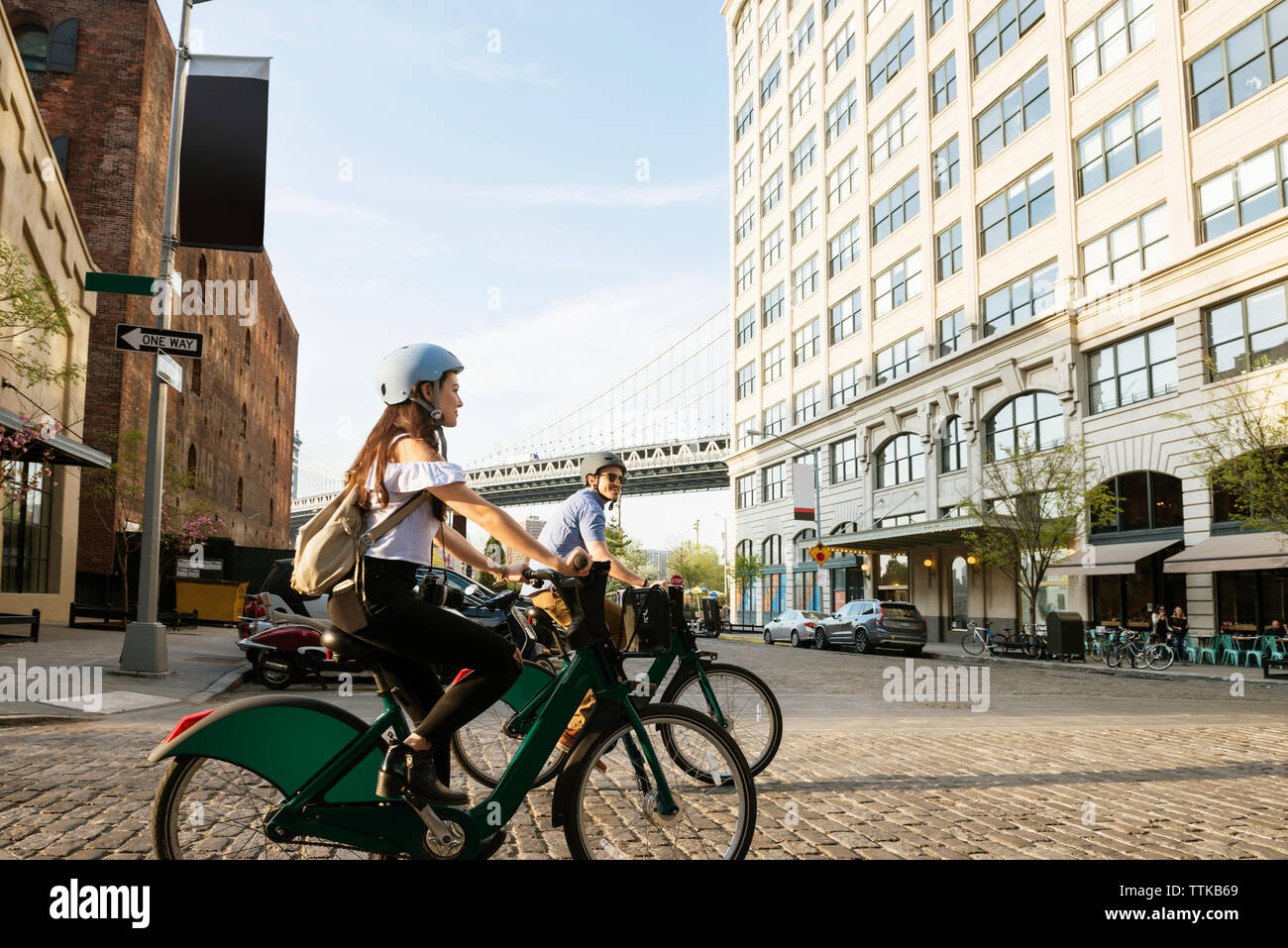 Giovane ciclismo su strada contro edifici in città Foto Stock