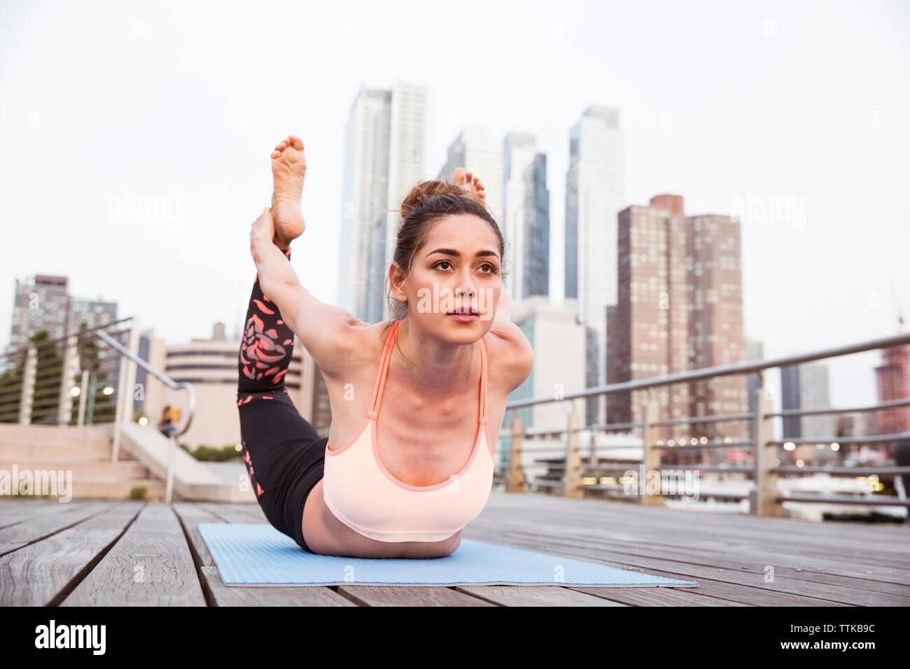 Donna facendo bow pongono sul ponte in città Foto Stock