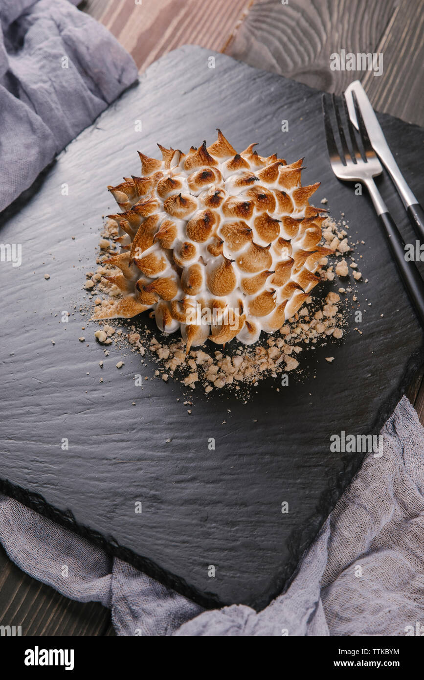 Angolo di Alta Vista della torta con grigliate di meringa su lavagna Foto Stock