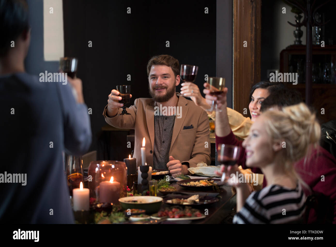 Amici che brindano vino a tavola durante il natale Foto Stock