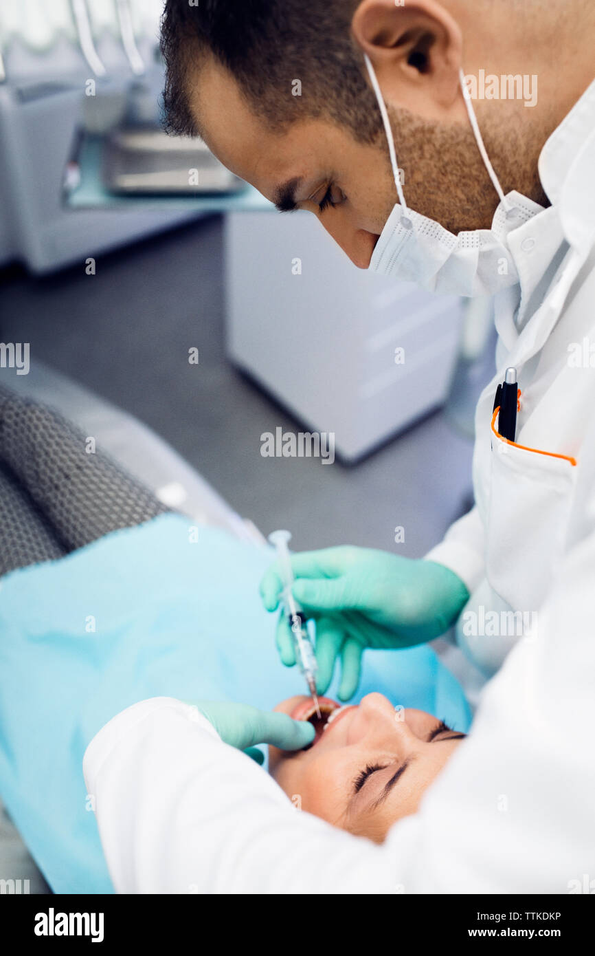 Dentista dando iniezione al paziente presso la clinica Foto Stock