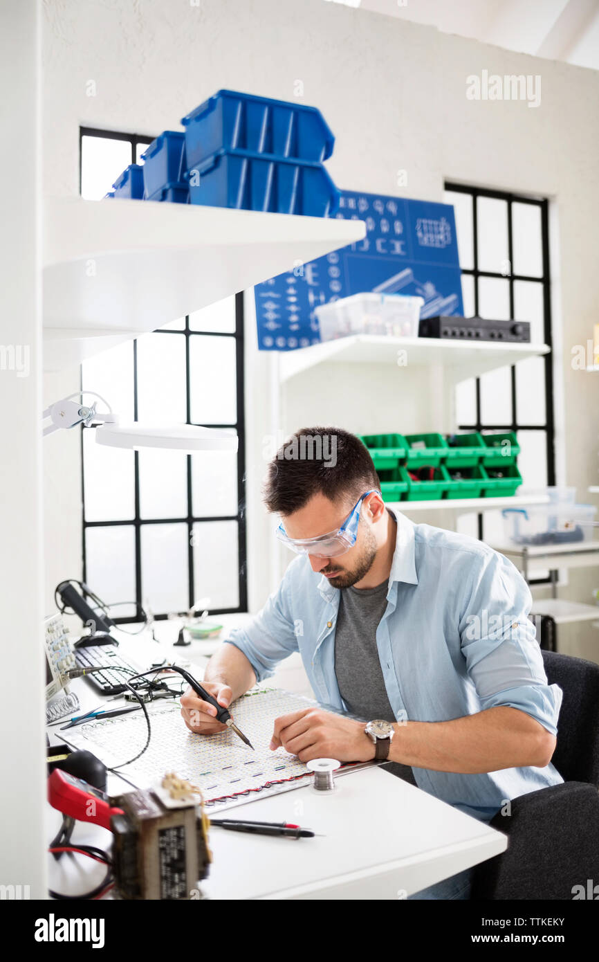 Concentrato tecnico circuito di saldatura in corrispondenza di industria elettronica Foto Stock