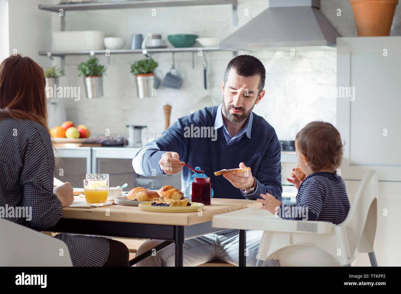 Famiglia con prima colazione nella cucina di casa Foto Stock