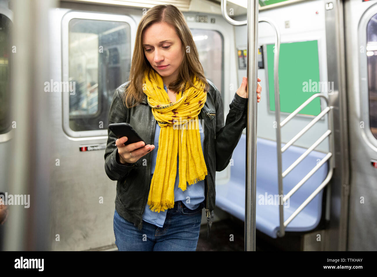 Donna che utilizza smart phone durante il viaggio in treno Foto Stock