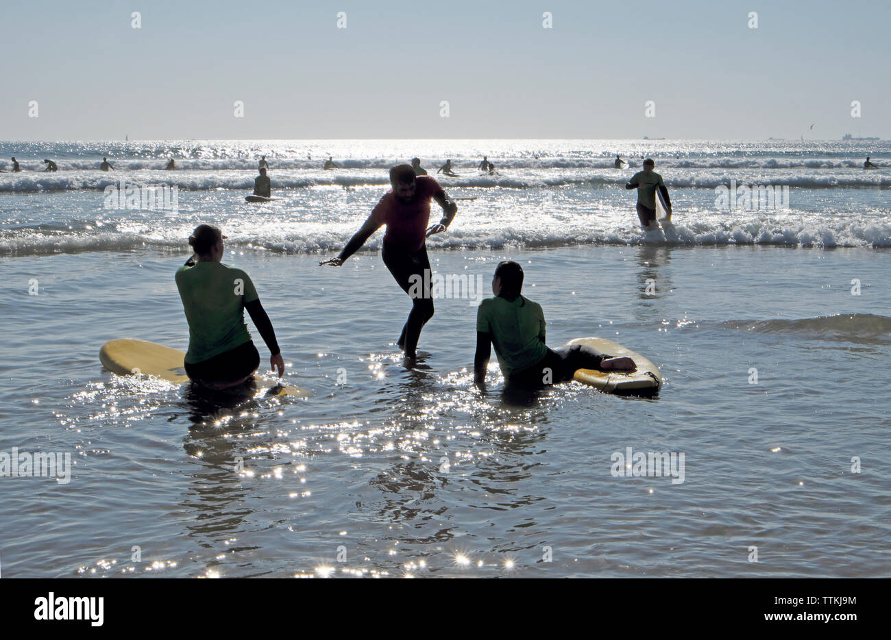 Un istruttore di surf dimostrando posture di surf per le giovani donne di imparare a navigare in vacanza a Matosinhos Porto Portogallo Europa KATHY DEWITT Foto Stock