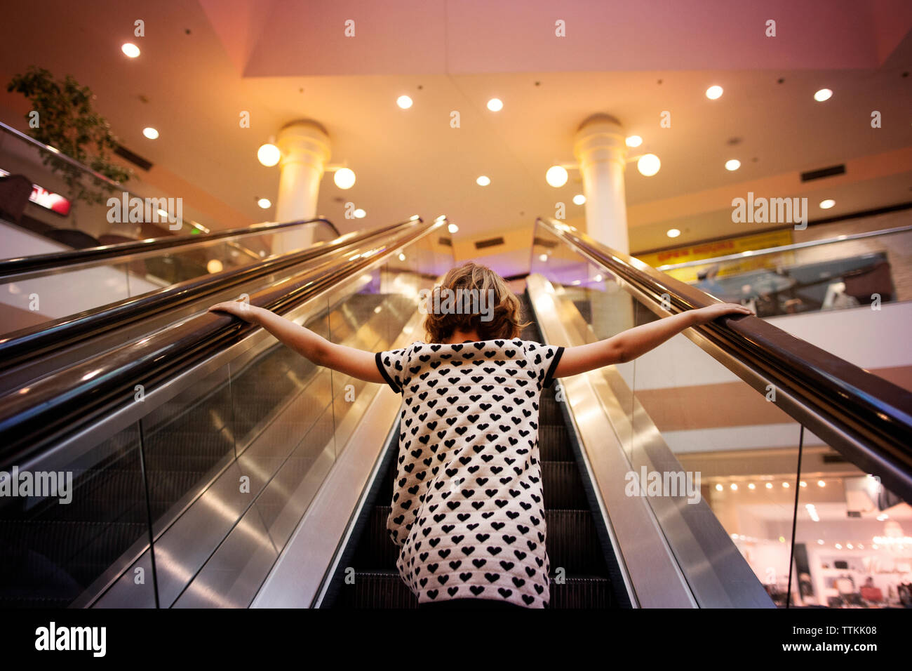 Basso angolo vista della ragazza in piedi sulla scala mobile Foto Stock