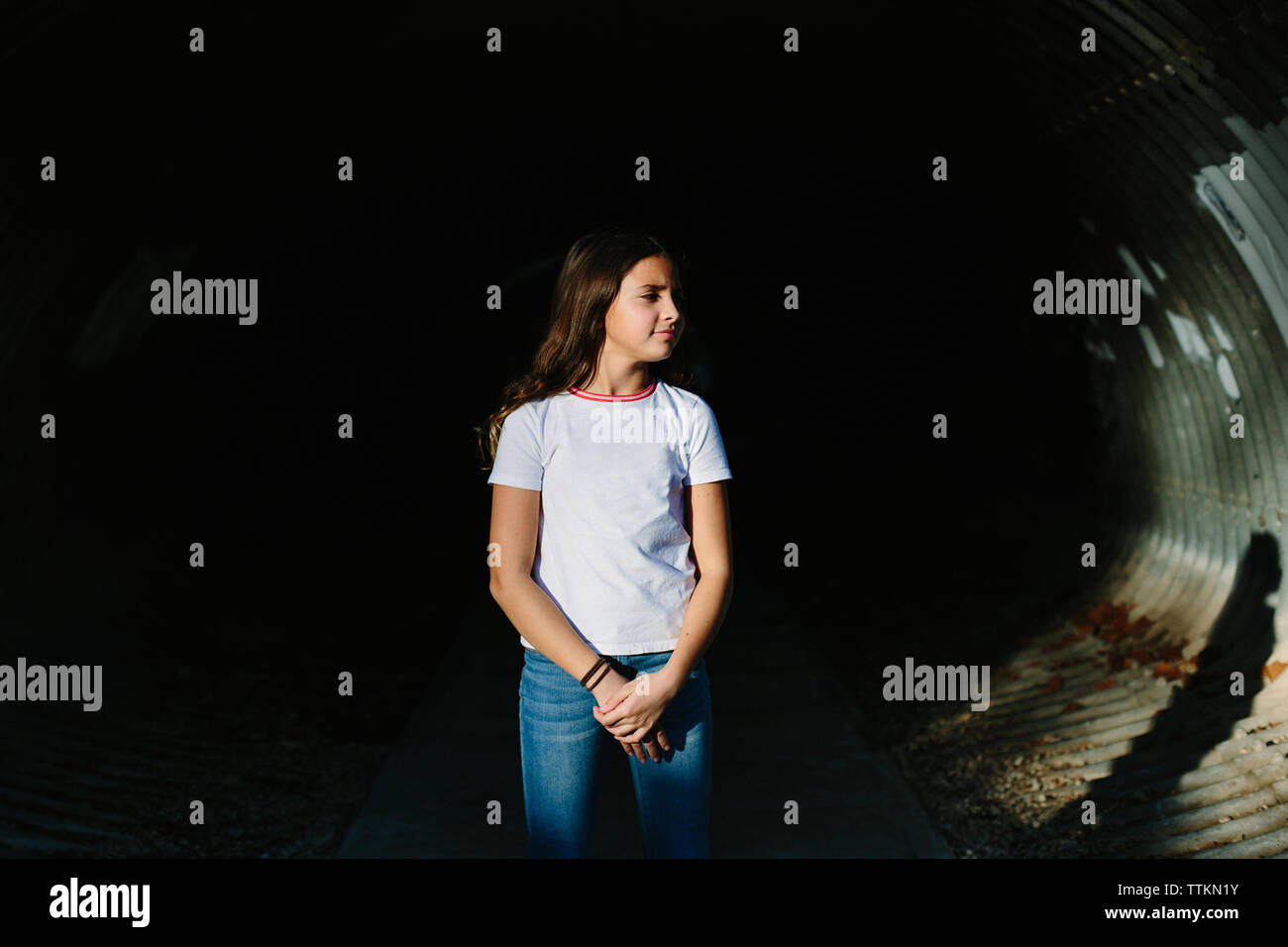 Tween girl sorge nel tunnel di luce diretta Foto Stock