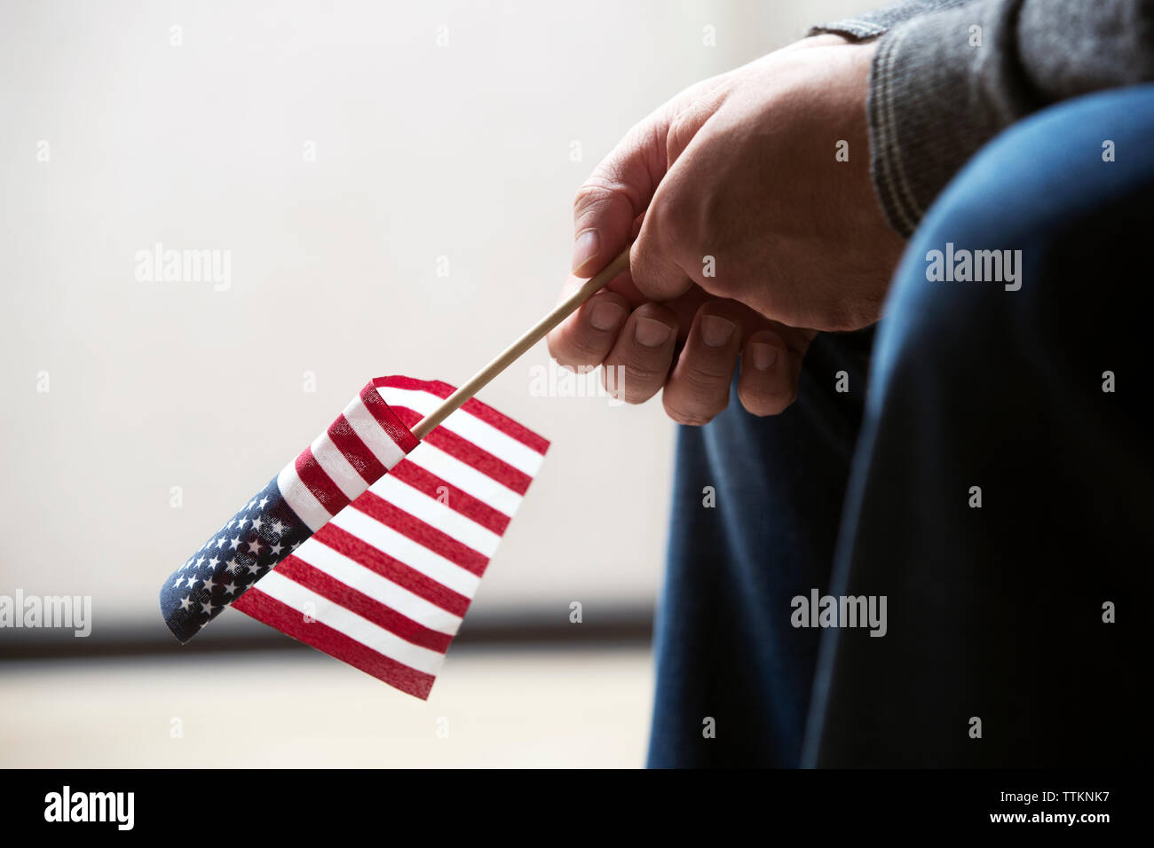 Immagine ritagliata della persona in possesso di bandiera americana Foto Stock