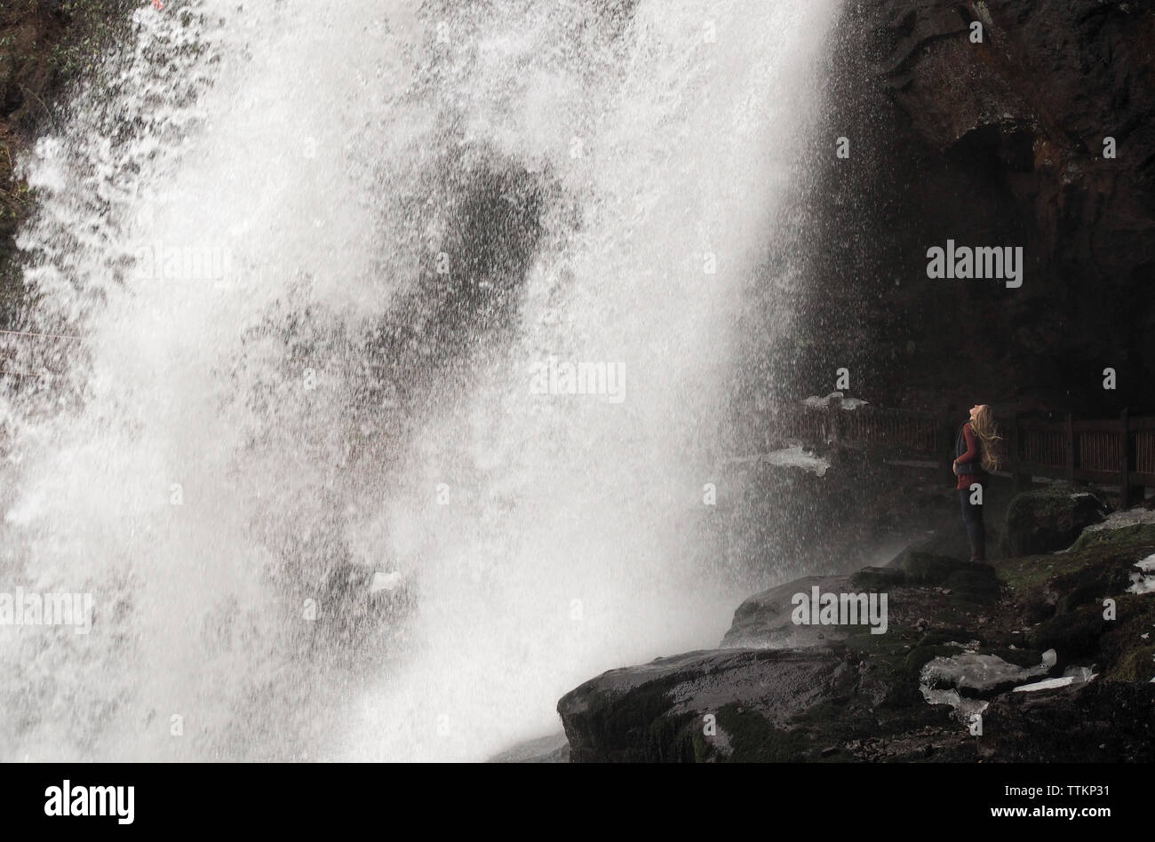 Vista laterale di un escursionista in piedi sulle rocce contro una cascata su Nantahala National Forest Foto Stock