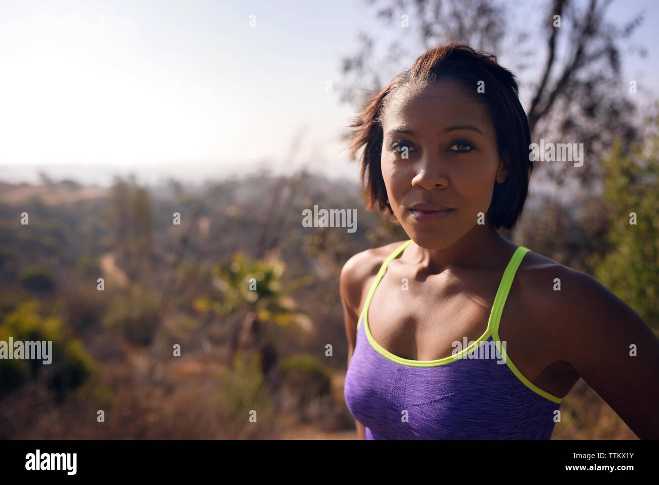 Ritratto di donna fiducioso in piedi sul campo durante la giornata di sole Foto Stock