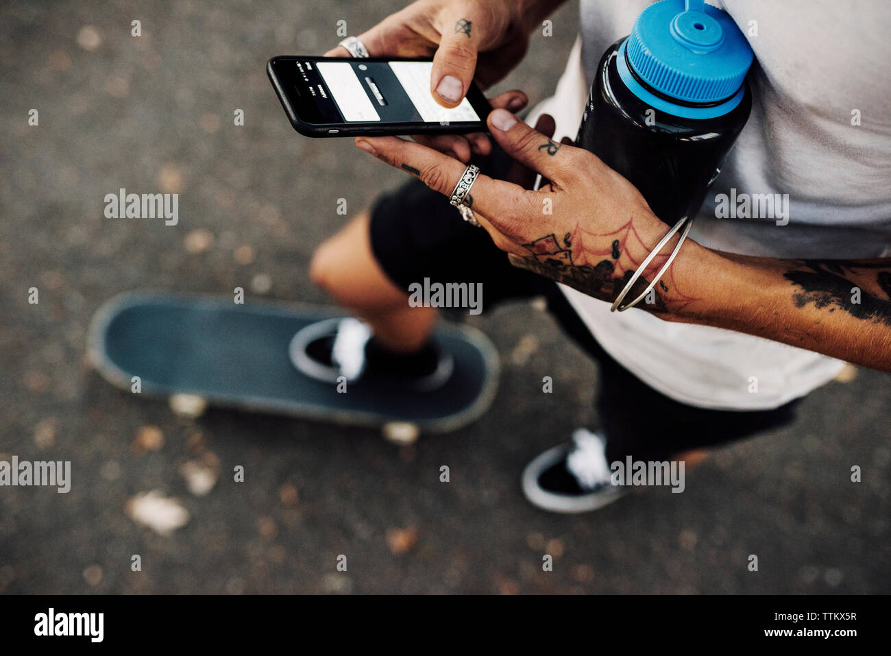 Sezione bassa dell'uomo utilizzando il telefono cellulare mentre si sta in piedi sul street Foto Stock