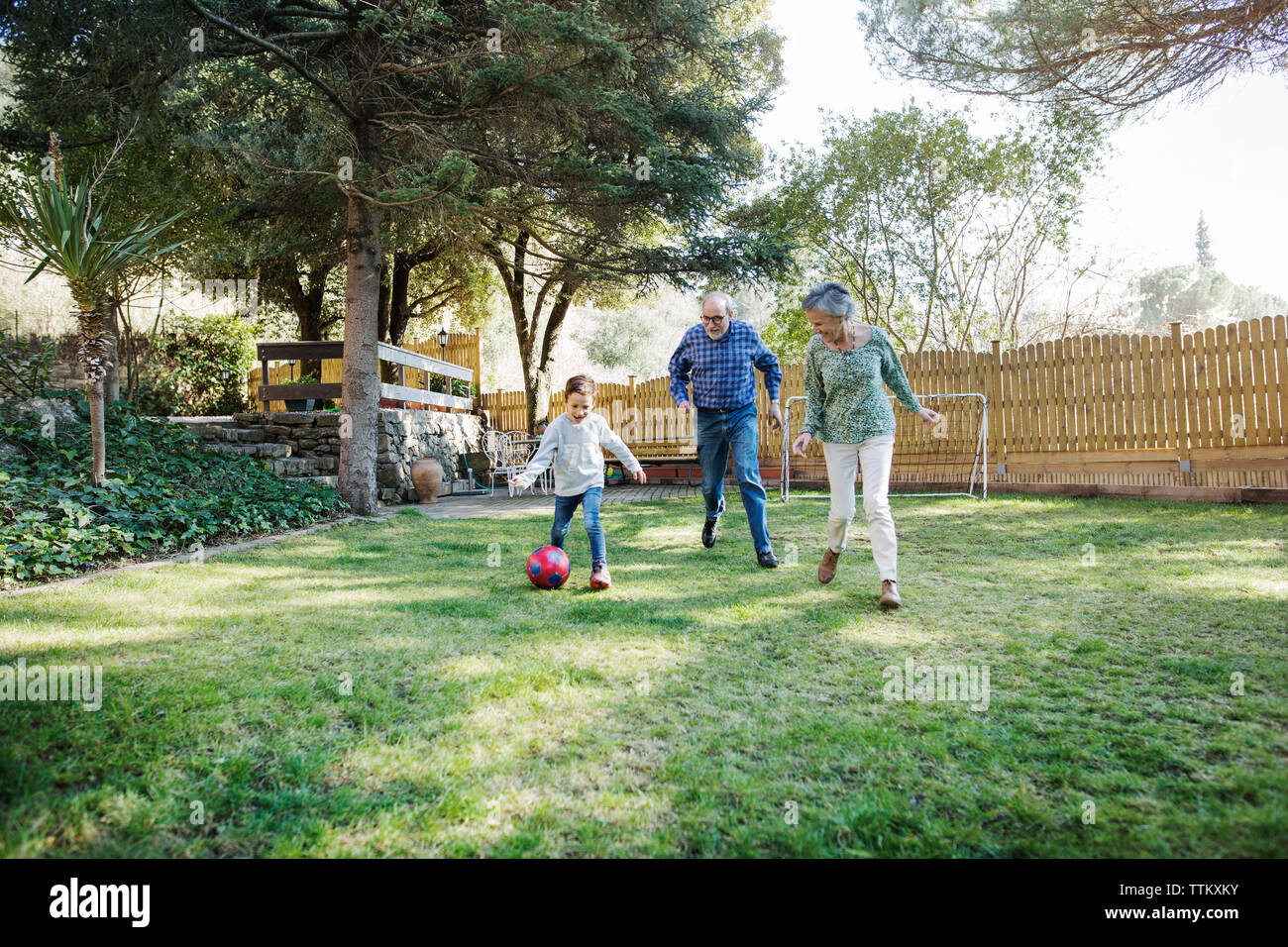 Nonni che giocano a calcio con il nipote in cantiere Foto Stock