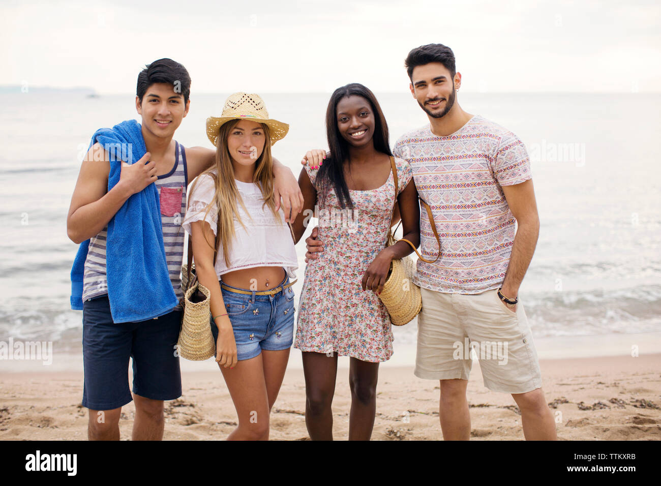 Ritratto di felice multi-etnico amici permanente sulla spiaggia Foto Stock