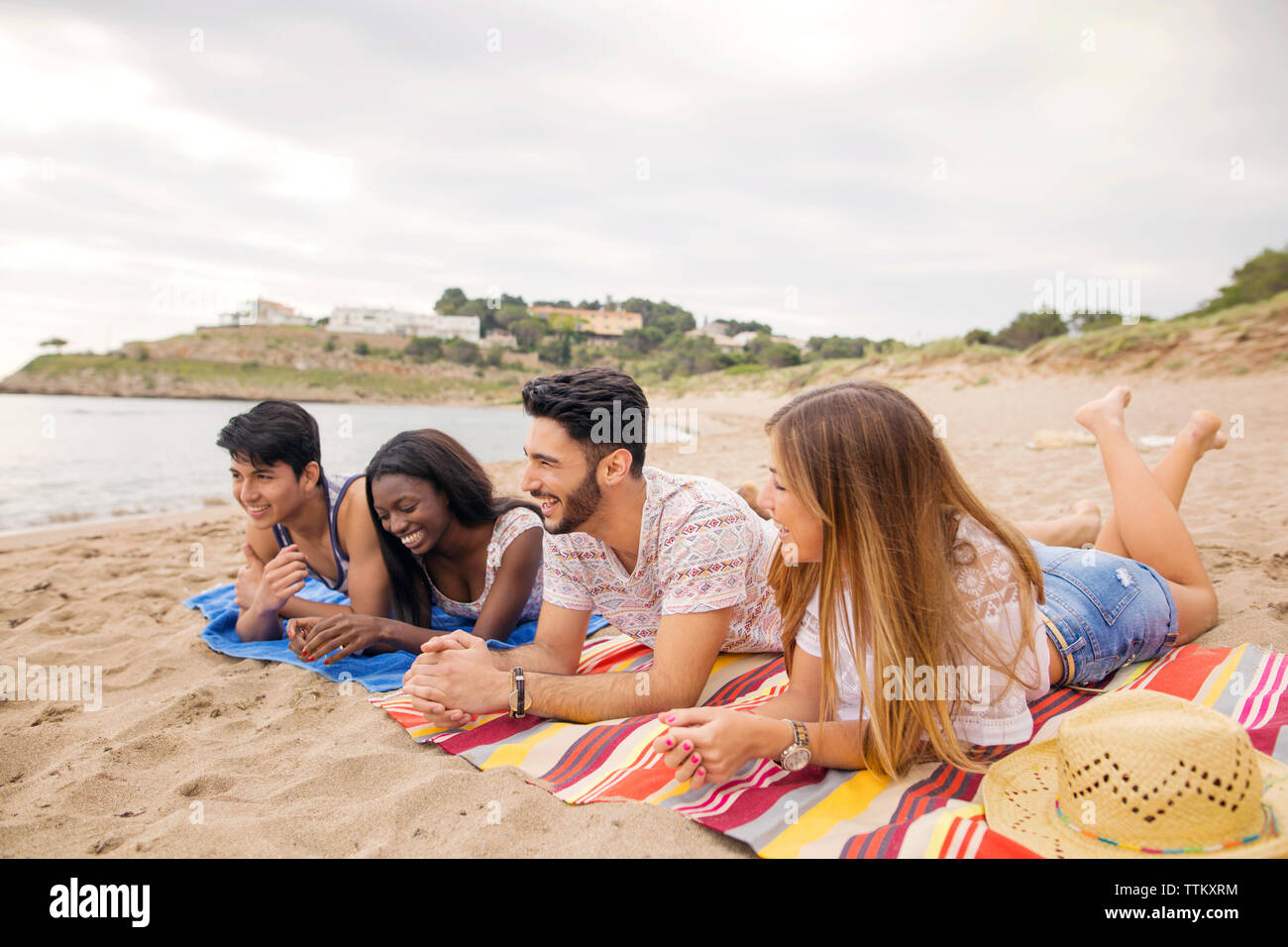 Felice multi-etnico amici rilassante in riva al mare Foto Stock