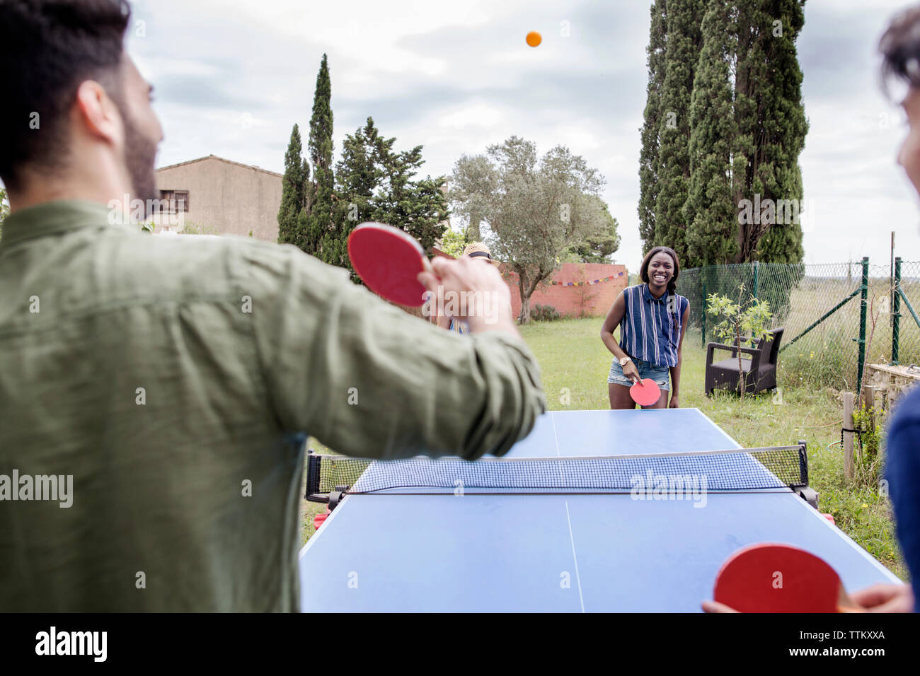 Multi-etnico amici giocando a ping-pong in cantiere Foto Stock