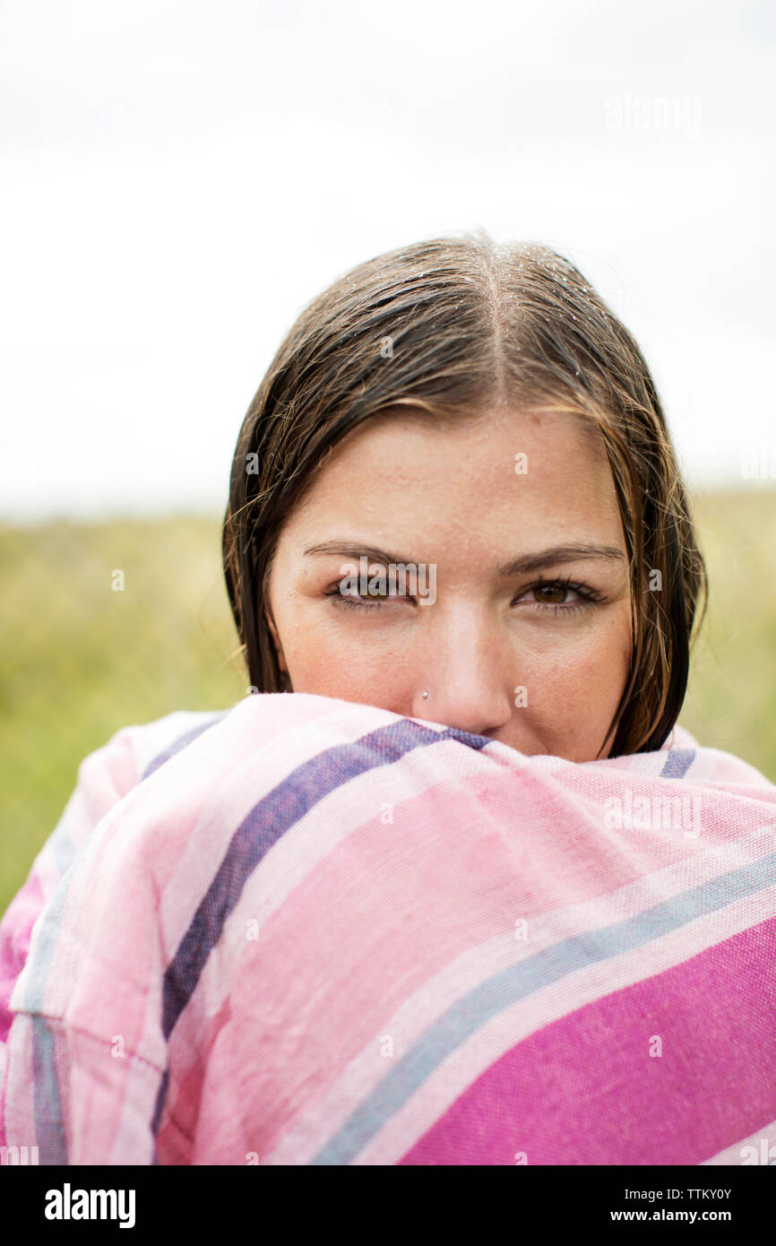 Ritratto di donna bagnato avvolto in asciugamano in cantiere Foto Stock