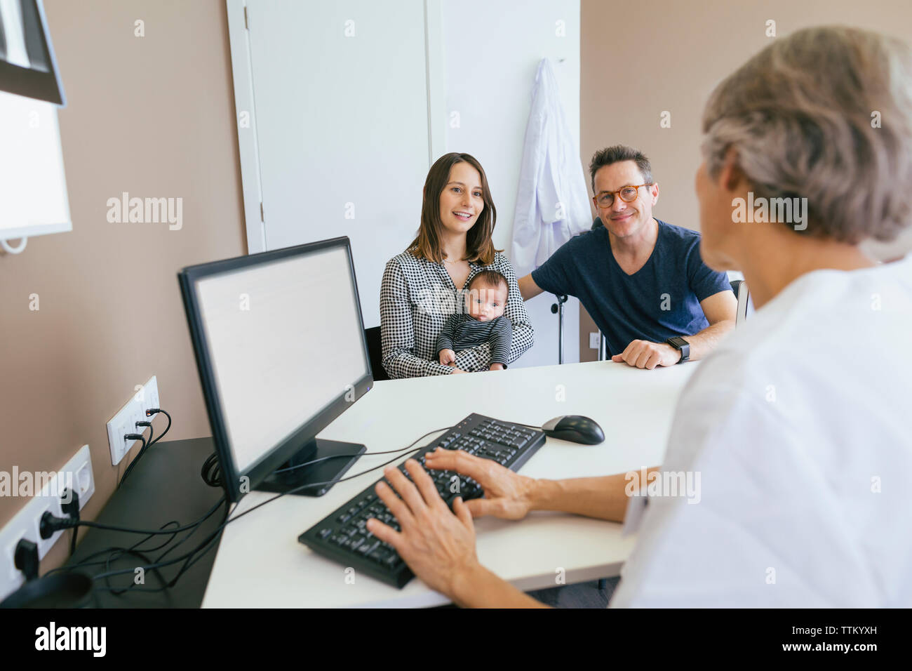 La famiglia felice a discutere con il medico presso la clinica medica Foto Stock