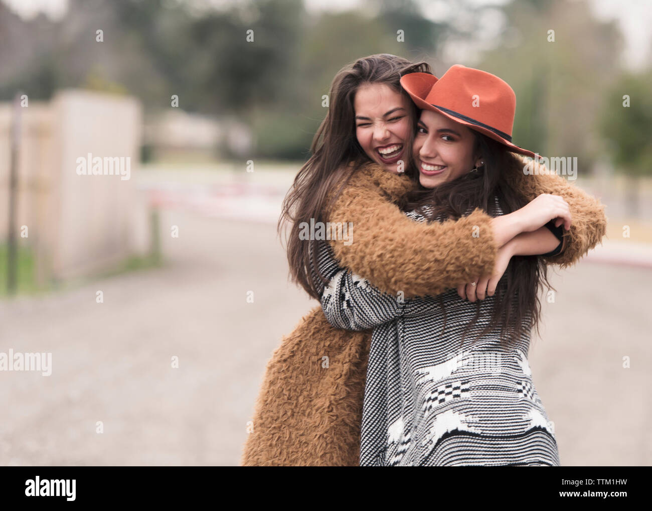 Happy amici ridere e abbracciando in strada. Foto Stock