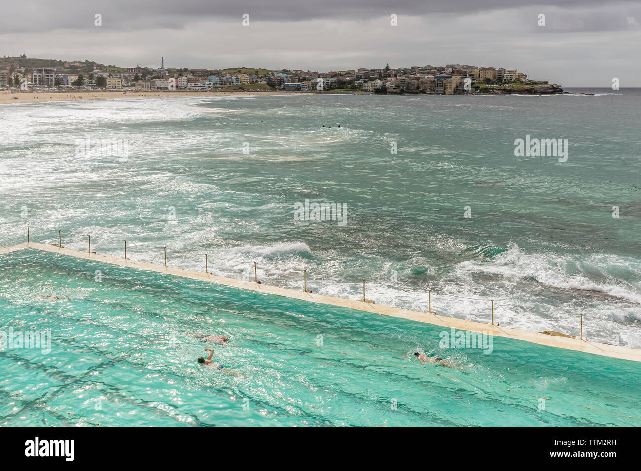 Bella vista aerea di Bondi Beach in un giorno nuvoloso con grandi onde e un po' di sole che filtra attraverso le nubi, Sydney, Australia Foto Stock