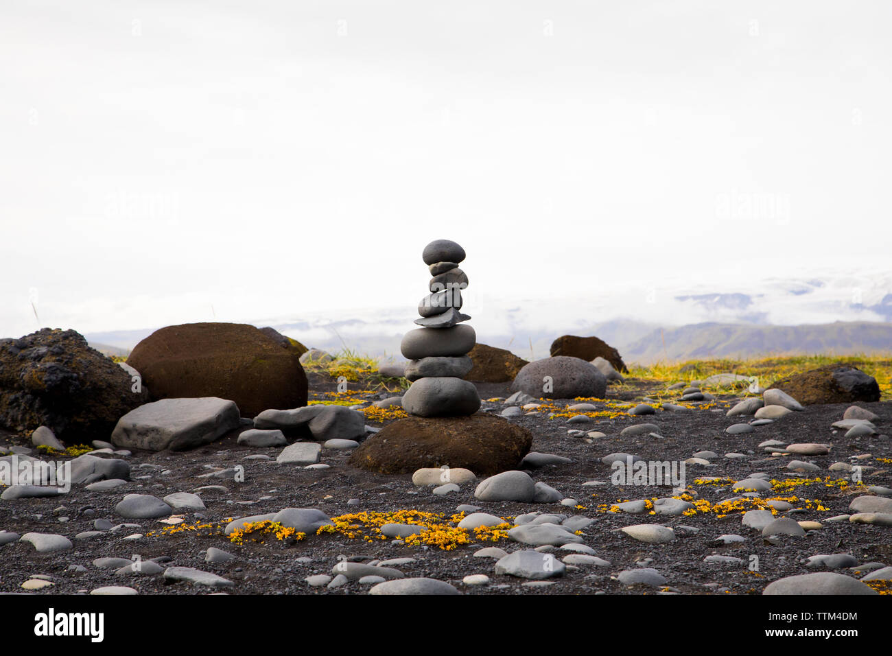 Cairn pila di rocce in equilibrio alla spiaggia Rynisfjara in Islanda Foto Stock