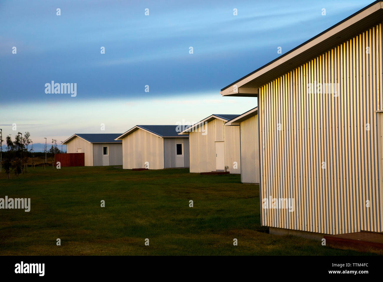 Gruppo di semplice moderni edifici metallici a sunrise in Islanda Foto Stock