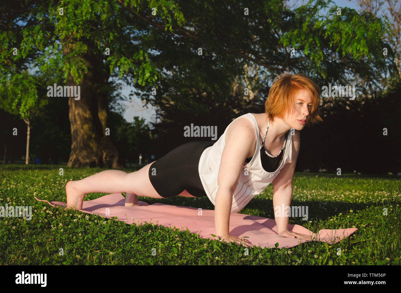 La donna a praticare yoga sul tappeto di esercizio in posizione di parcheggio Foto Stock