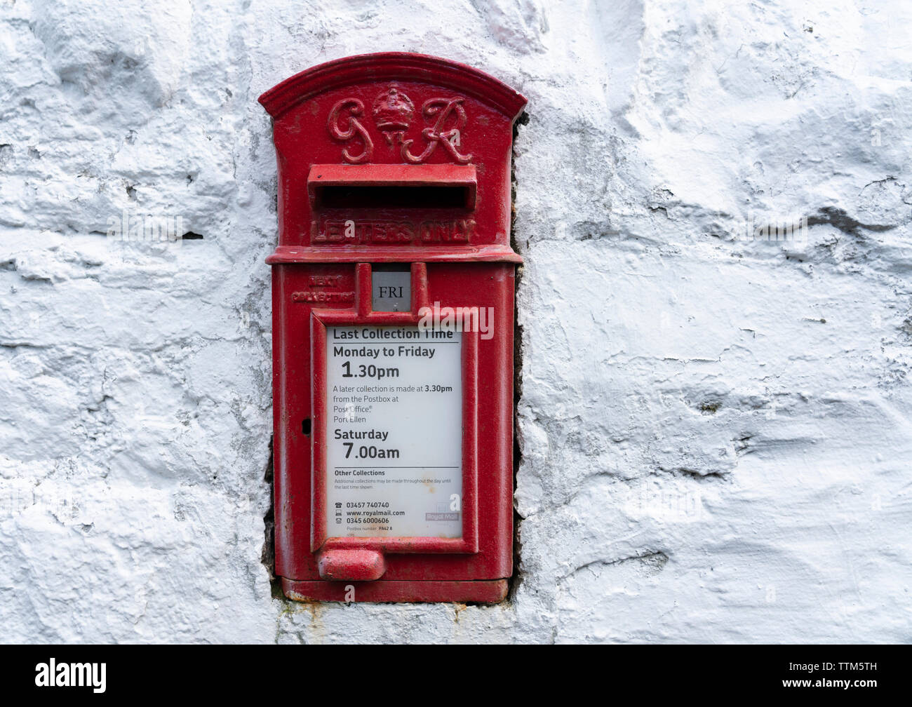 Dettaglio di un tradizionale vecchio rosso postbox sul muro bianco Foto Stock