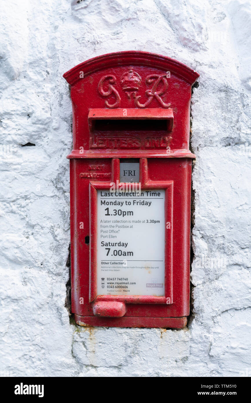 Dettaglio di un tradizionale vecchio rosso postbox sul muro bianco Foto Stock