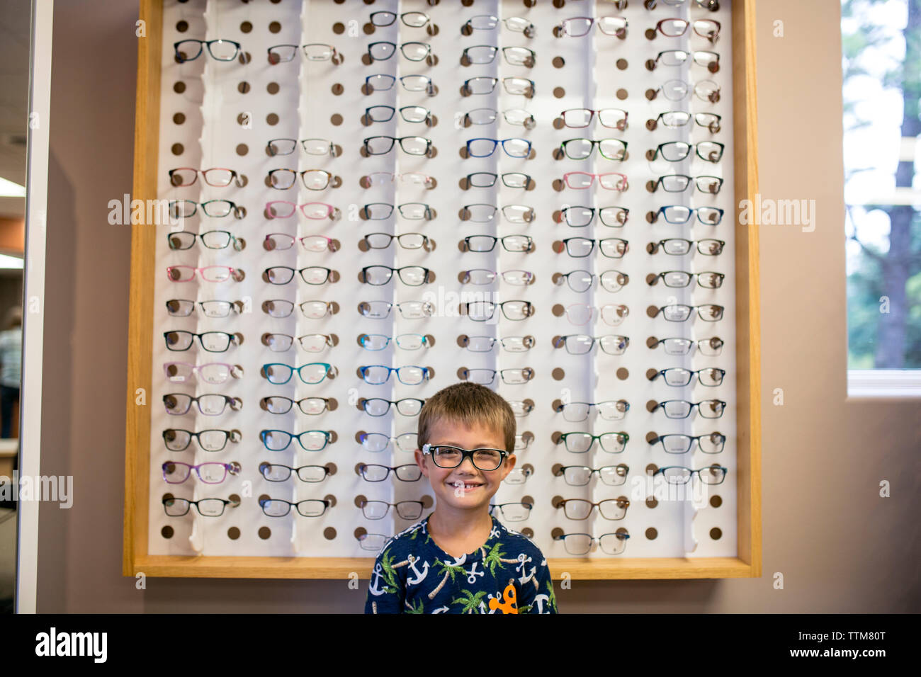 Giovane ragazzo eccitato in vetro da indossare in ufficio medici Foto Stock