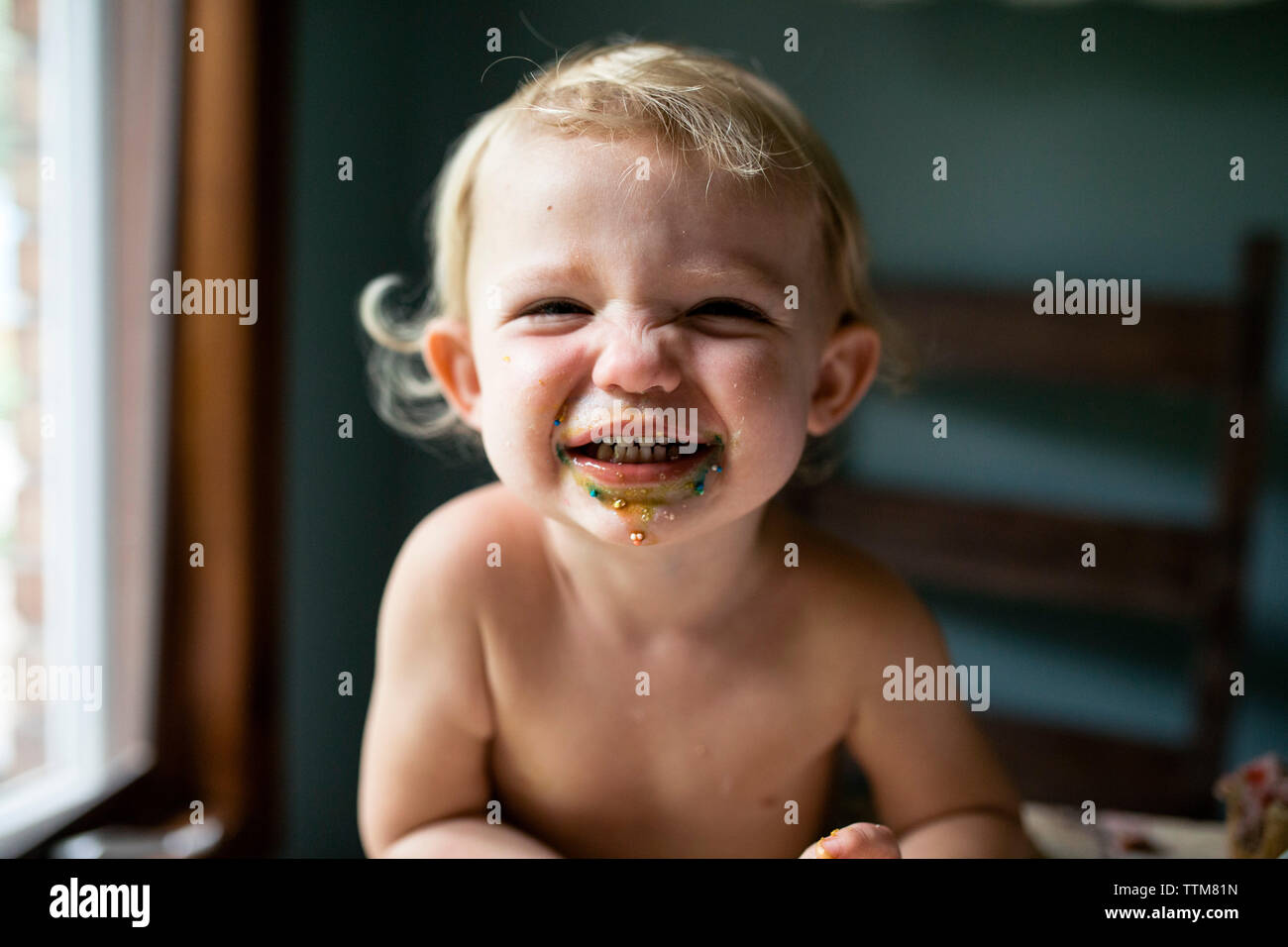 Il Toddler ragazza sorridente dopo aver mangiato il Dolcetto Foto Stock