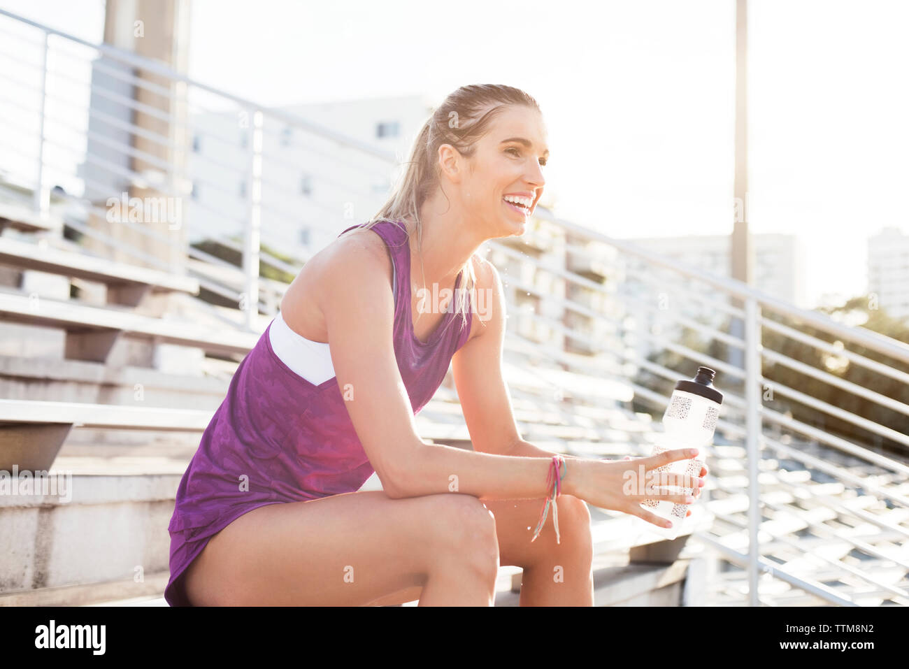 Felice atleta donna seduta sulle gradinate Foto Stock