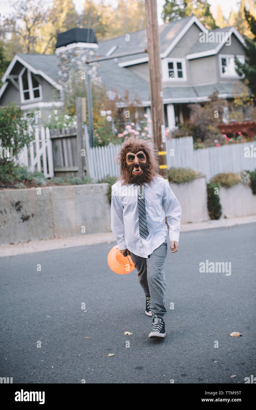 Ragazzo in costume di Halloween mentre si cammina sulla strada Foto Stock