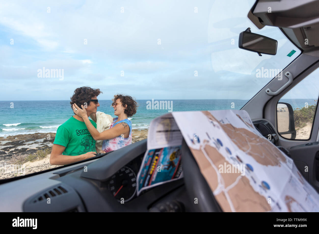 20 30 anni bianco giovane costeggiata sulla spiaggia al di fuori del loro furgone Foto Stock