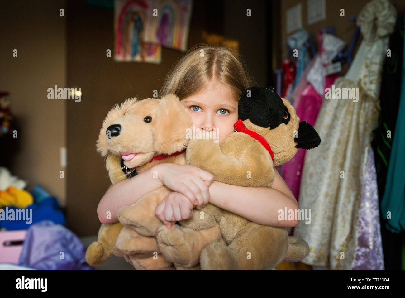 Ragazza con giocattoli imbottiti in camera da letto a casa Foto Stock