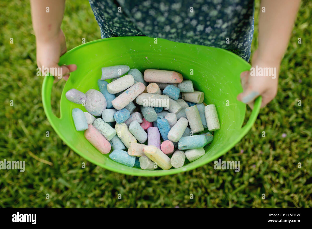 Sezione mediana della ragazza con gessi colorati in coppa a backyard Foto Stock