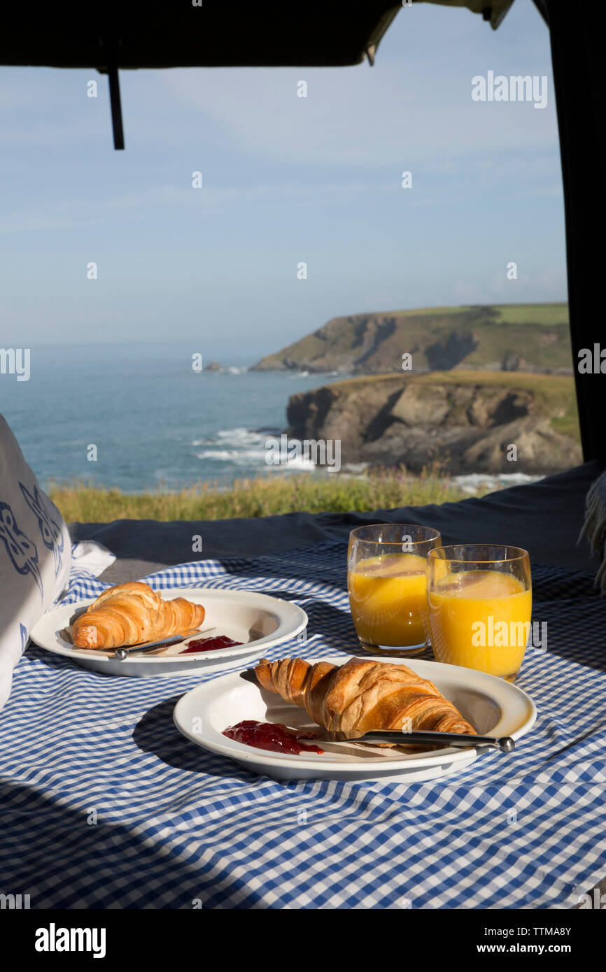 La prima colazione a letto dalla finestra contro il mare in casa a motore Foto Stock