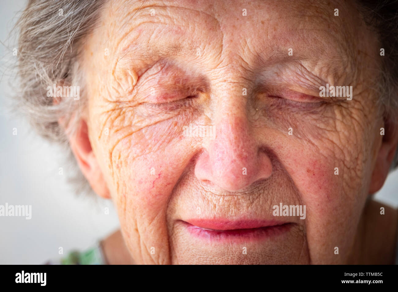 Close-up di triste senior donna con gli occhi chiusi Foto Stock