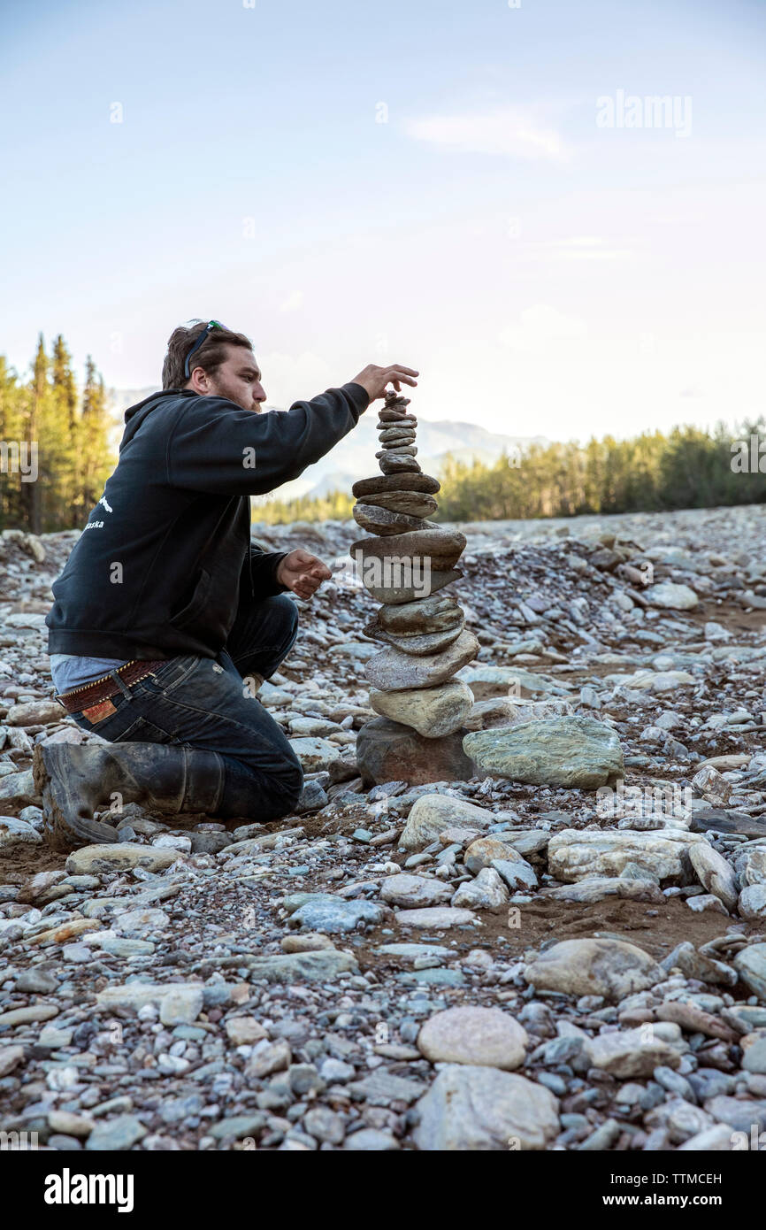 Stati Uniti d'America, Alaska Denali National Park, una guida costruisce cairns durante una pausa dal tour ATV a Stampede Ridge Foto Stock