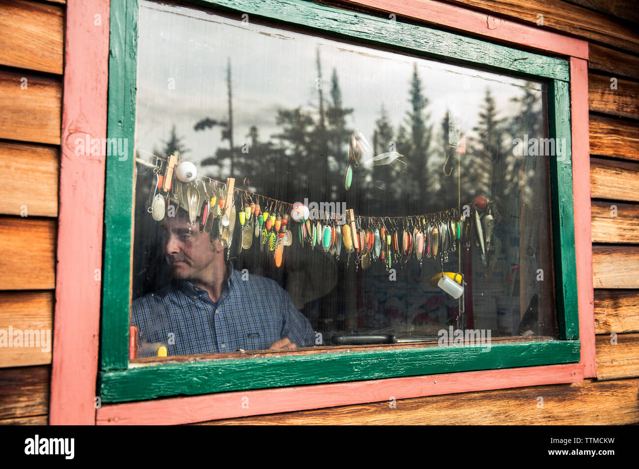 Stati Uniti d'America, Alaska, Omero, Cina Poot baia Kachemak Bay, figlio dei proprietari che fissa la collezione di esche artificiali al Kachemak Bay Wilderness Lodge Foto Stock