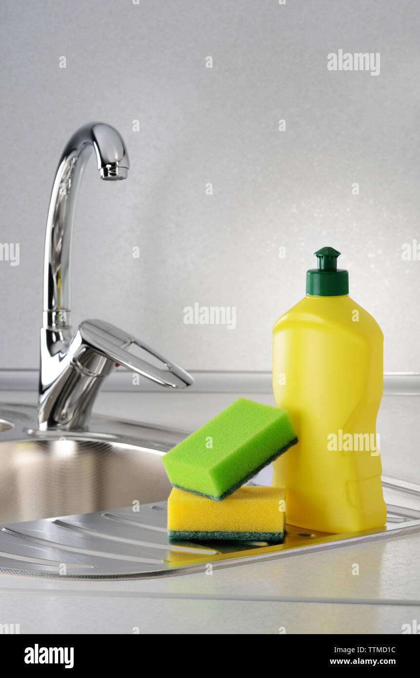 Detersivo liquido per stoviglie con una spugna sul lavello da cucina Foto Stock