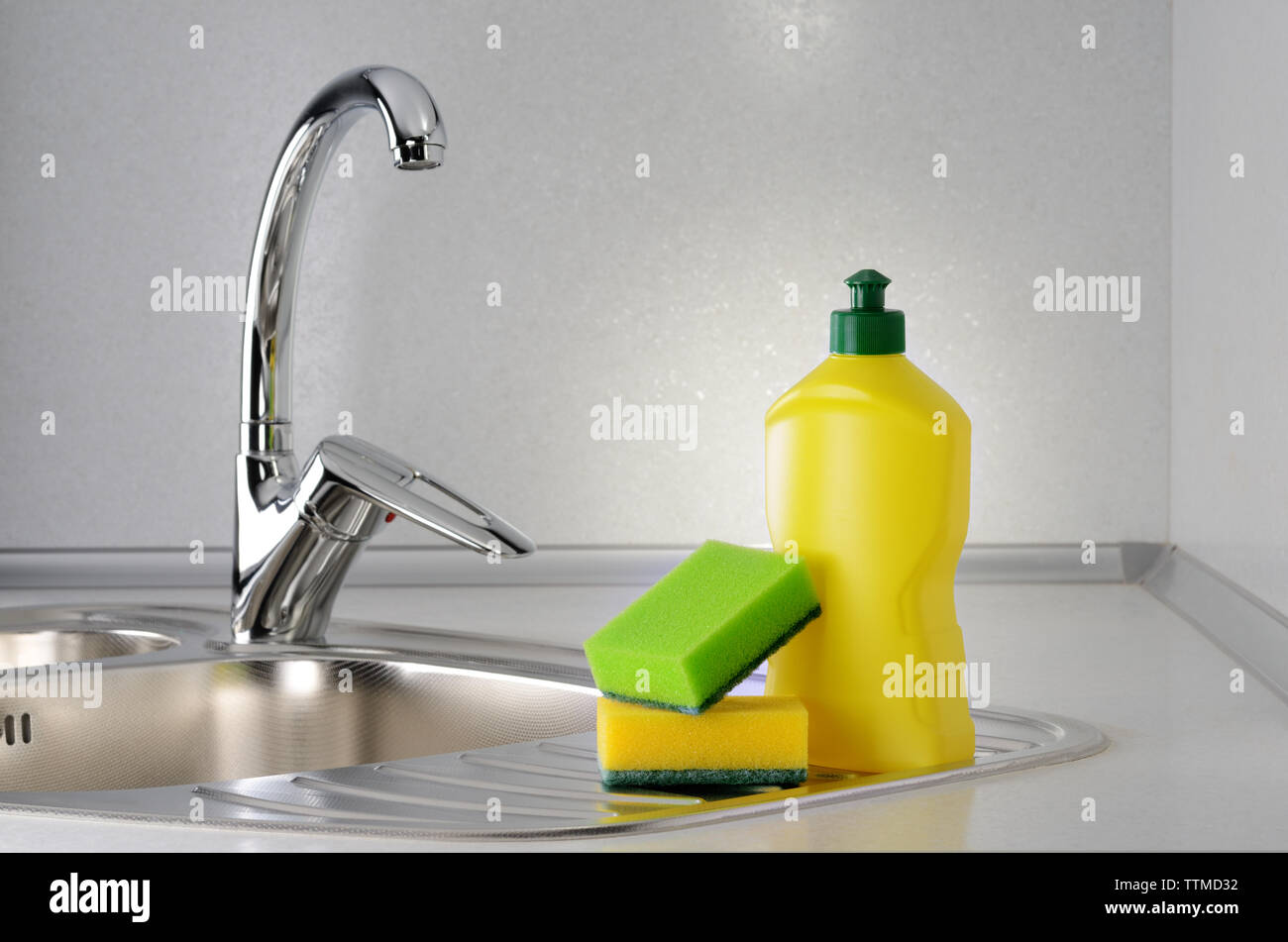 Detersivo liquido per stoviglie con una spugna sul lavello da cucina Foto Stock