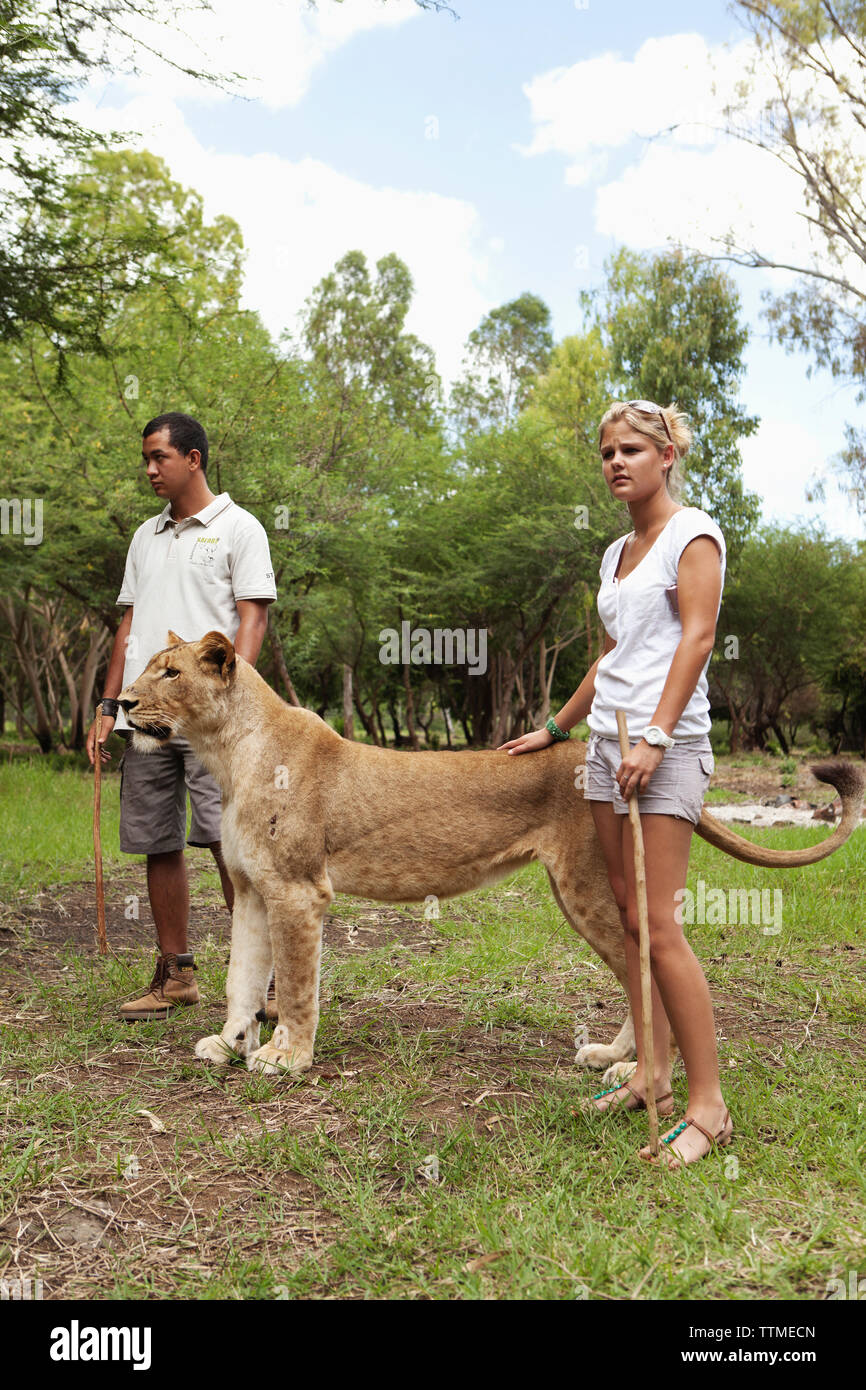 Maurizio, Flic en Flac, turistico, Samantha Luyt dal Sud Africa, sorge a fianco di una leonessa a Casela natura e il parco di divertimenti a western Maurit Foto Stock