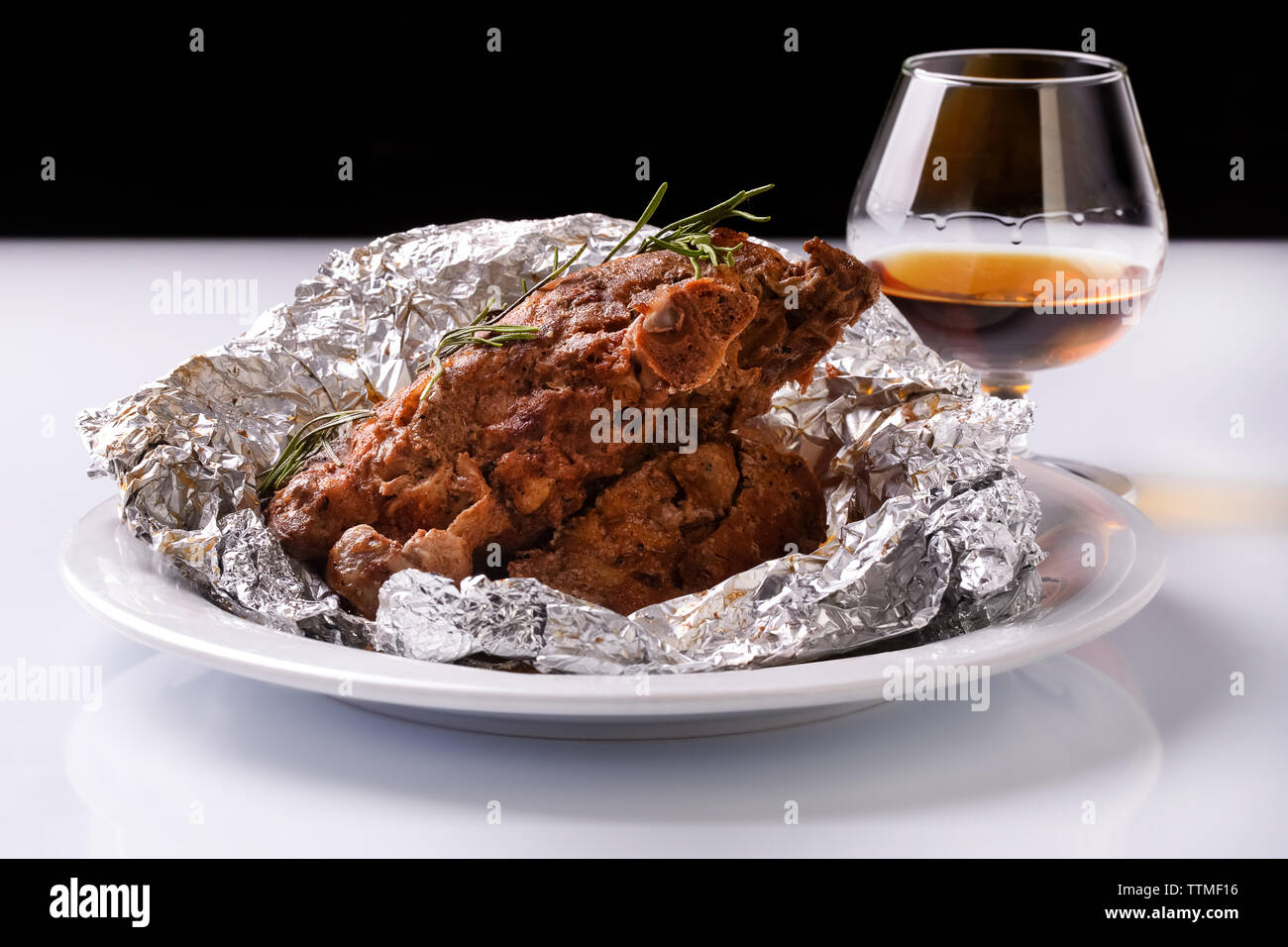 Agnello grigliate di nervature della piastra rivestita in lamina di alluminio con il brandy o il cognac Foto Stock