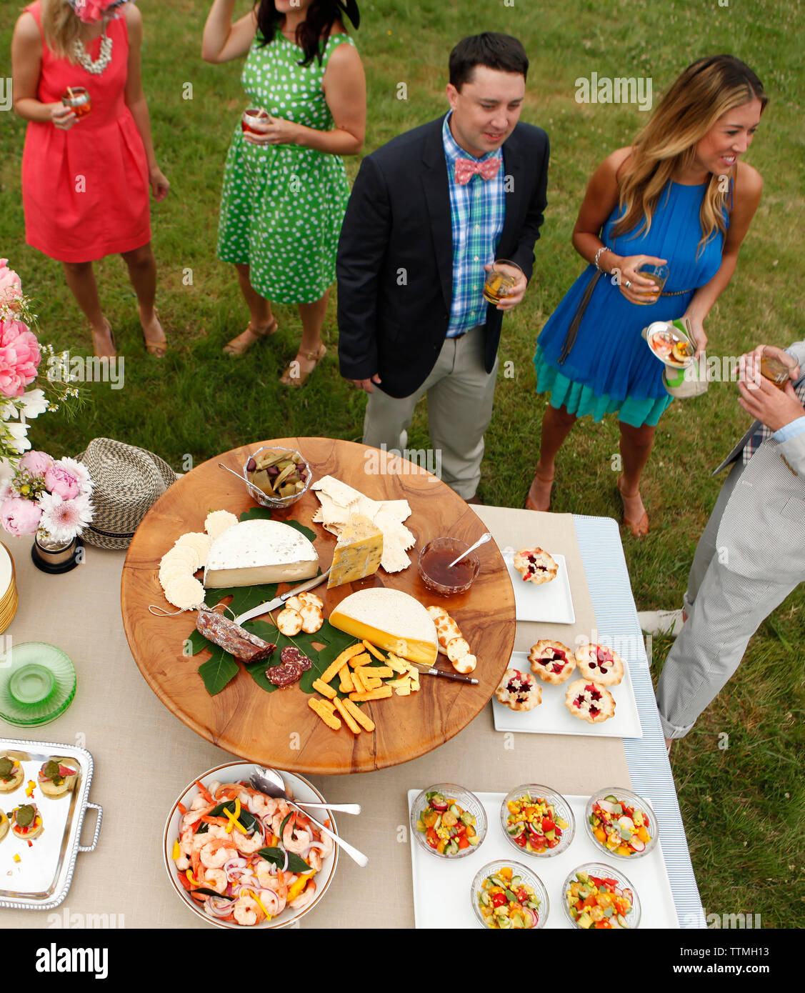 Stati Uniti d'America, Tennessee, Nashville, Iroquois siepi, stand di amici intorno a un tavolo da buffet di mangiare e di bere Foto Stock