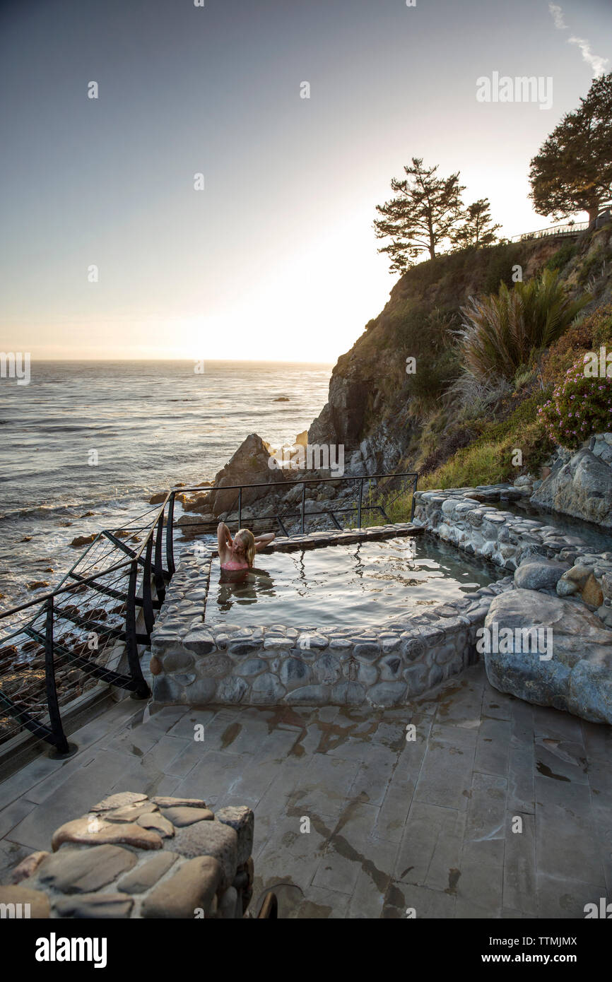 Stati Uniti, California, Big Sur, Esalen, una donna fissa la sua tuta presso le Terme con la Pacifc il mare in lontananza, il Esalen Institute Foto Stock