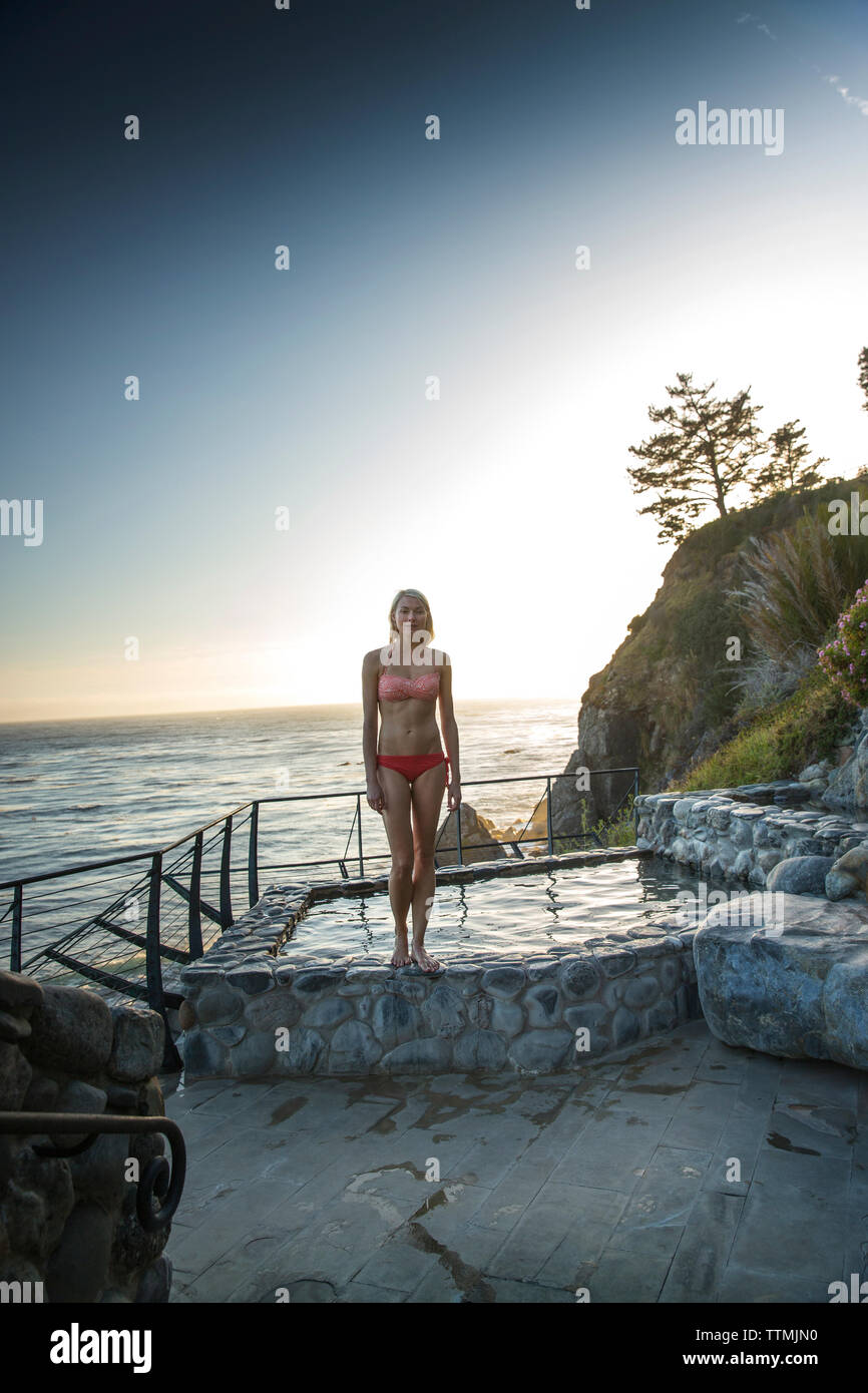 Stati Uniti, California, Big Sur, Esalen, una donna viene fuori delle Terme con il Pacifc il mare in lontananza, il Esalen Institute Foto Stock